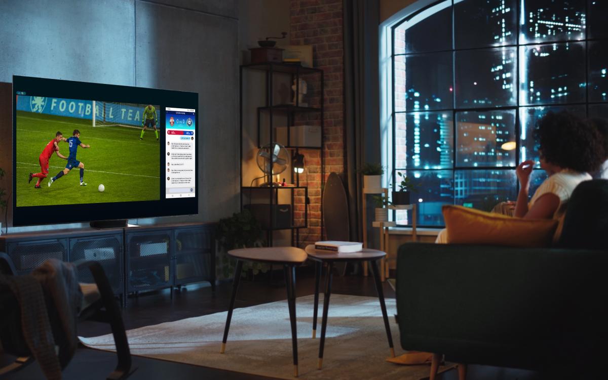 Kobieta ogląda mecz piłki nożnej na telewizorze Smart TV Samsung